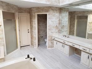 bathroom featuring hardwood / wood-style floors, vanity, toilet, and a bath