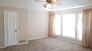 carpeted empty room with ceiling fan and ornamental molding