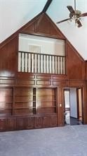 interior space featuring wooden walls, high vaulted ceiling, and ceiling fan