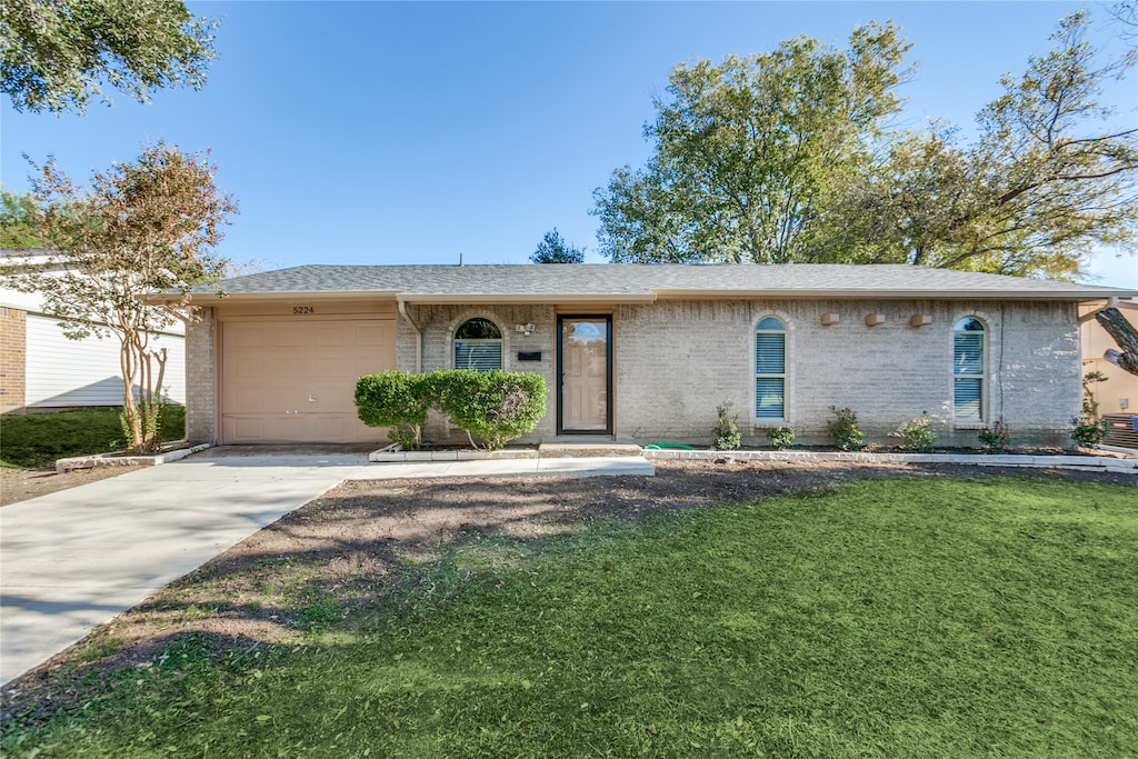 single story home with a front lawn and a garage