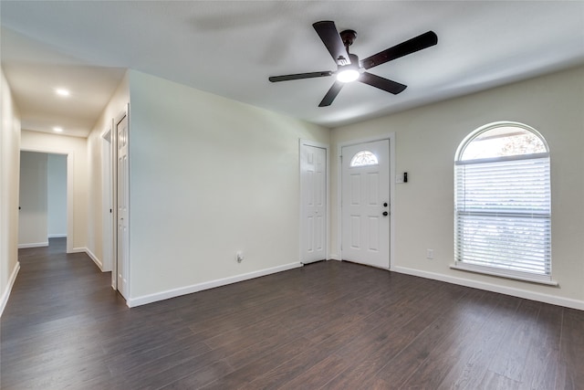 foyer entrance with ceiling fan and dark wood-type flooring