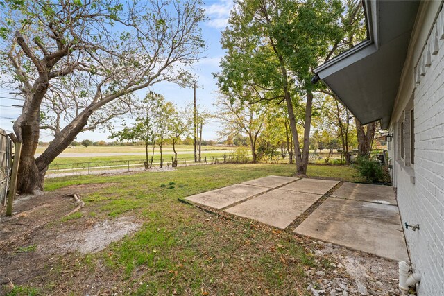 view of yard with a rural view and a patio area