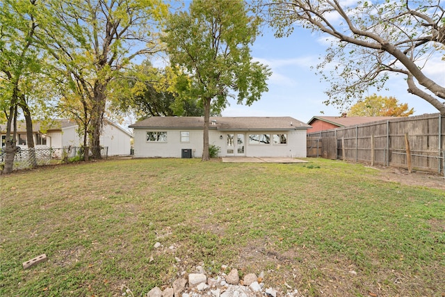 rear view of house featuring a lawn, cooling unit, and a patio