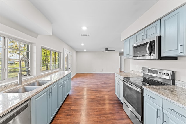 kitchen with sink, ceiling fan, light stone countertops, dark hardwood / wood-style flooring, and stainless steel appliances