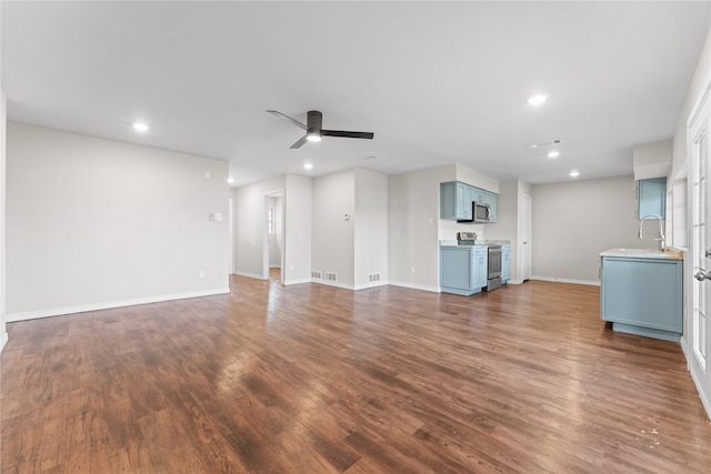 unfurnished living room with ceiling fan, dark hardwood / wood-style flooring, and sink