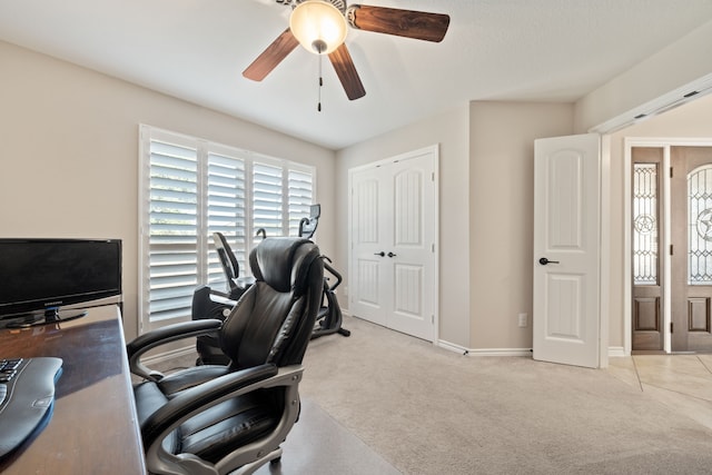 carpeted office space featuring ceiling fan