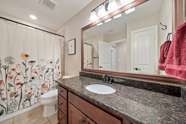 bathroom with toilet, vanity, tile patterned floors, and walk in shower