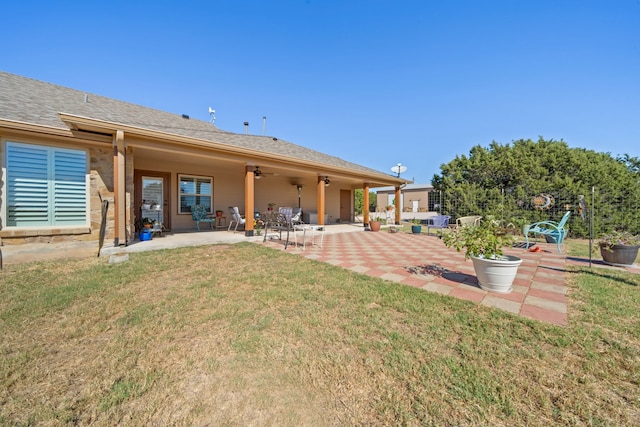 rear view of property featuring a patio area, ceiling fan, and a yard