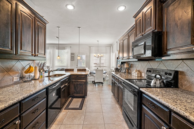 kitchen featuring sink, dark brown cabinetry, decorative light fixtures, and black appliances