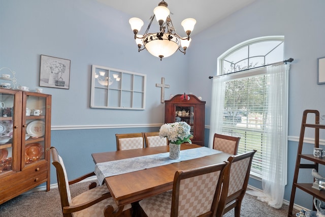 dining space with carpet and a chandelier