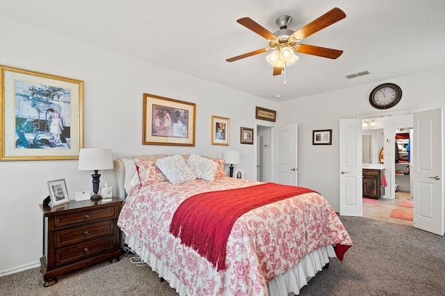 carpeted bedroom with ceiling fan and ensuite bath