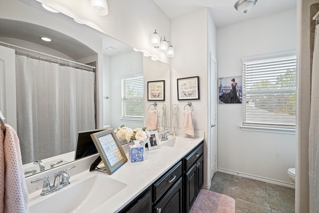 bathroom with vanity, toilet, and a healthy amount of sunlight