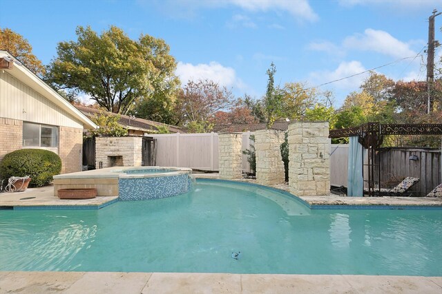 view of swimming pool with an in ground hot tub