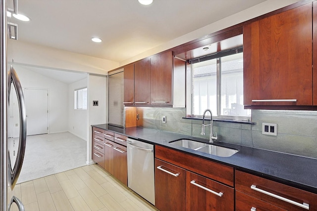 kitchen with tasteful backsplash, lofted ceiling, appliances with stainless steel finishes, and sink