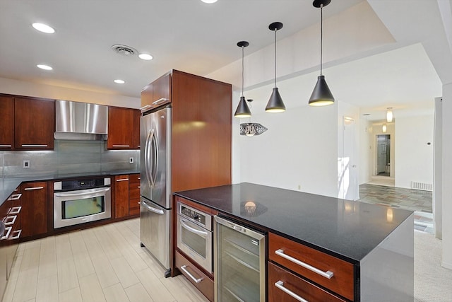 kitchen featuring pendant lighting, tasteful backsplash, wine cooler, stainless steel appliances, and wall chimney exhaust hood