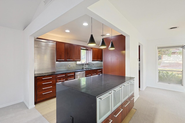 kitchen with pendant lighting, sink, decorative backsplash, a center island, and stainless steel dishwasher