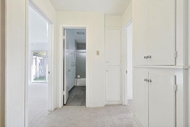 hall with light colored carpet