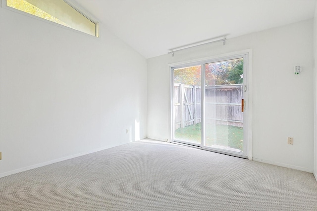 unfurnished room featuring lofted ceiling and carpet floors