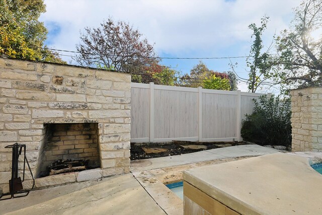 view of patio with an outdoor stone fireplace