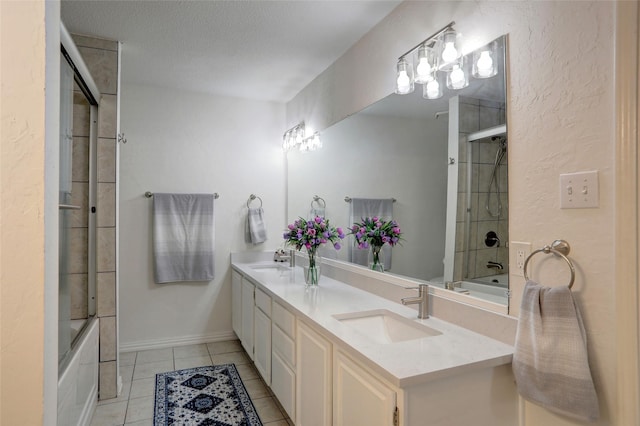 bathroom featuring vanity, a textured ceiling, tile patterned floors, and combined bath / shower with glass door