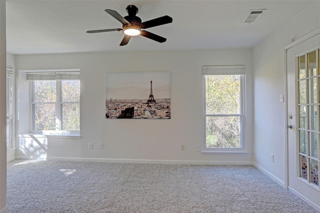 carpeted empty room with plenty of natural light and ceiling fan