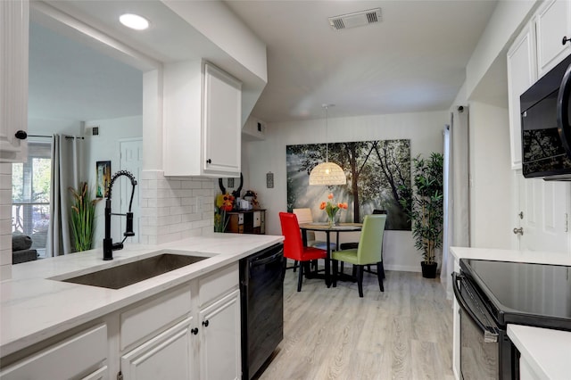 kitchen featuring white cabinets, sink, hanging light fixtures, and black appliances