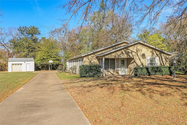 single story home with an outbuilding, a garage, and a front lawn