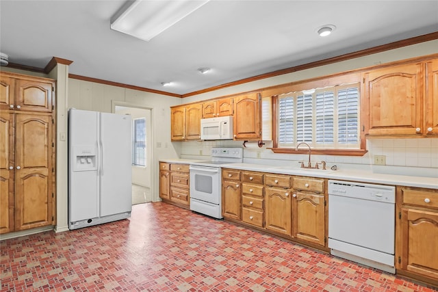 kitchen with a healthy amount of sunlight, white appliances, sink, and ornamental molding