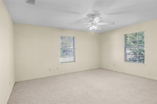 empty room featuring ceiling fan and light carpet