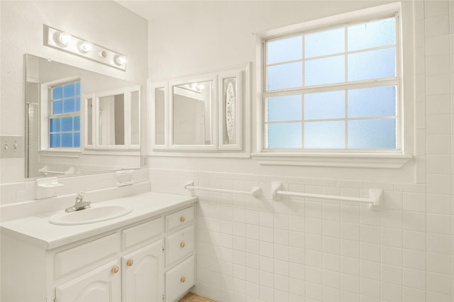 bathroom with vanity and tile walls