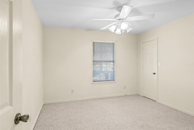 carpeted spare room with ceiling fan