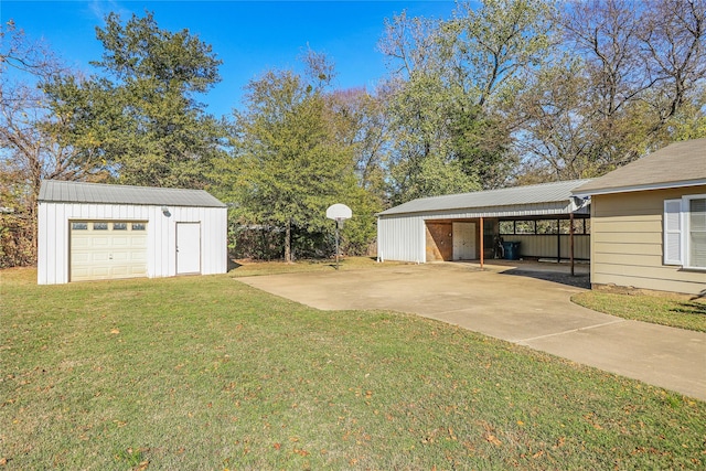 view of yard with a garage, a carport, and an outdoor structure