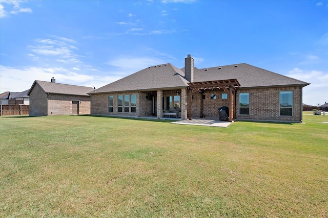 back of property with a pergola, a patio area, and a lawn