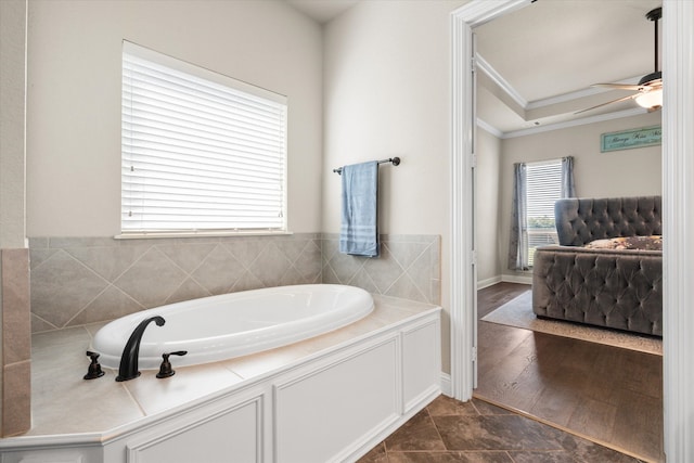 bathroom featuring a bathtub, ornamental molding, and ceiling fan