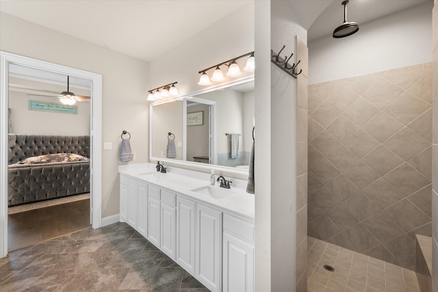 bathroom featuring ceiling fan, vanity, and a tile shower