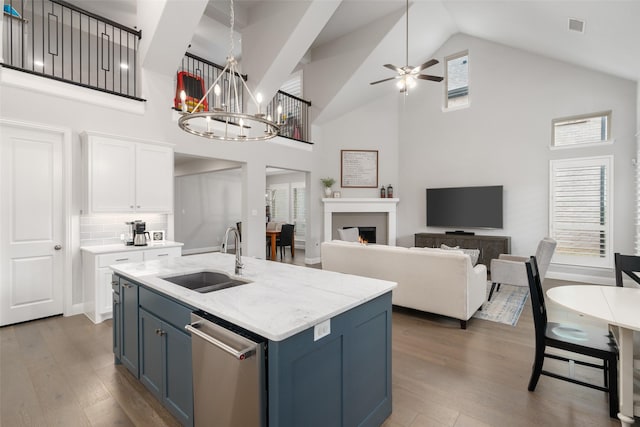 kitchen featuring dark hardwood / wood-style floors, blue cabinets, white cabinetry, sink, and stainless steel dishwasher