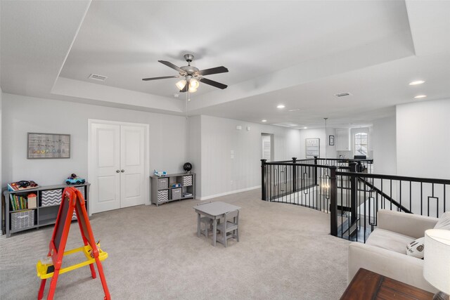 interior space featuring light colored carpet and a raised ceiling