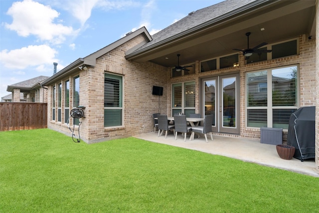 rear view of property with ceiling fan, a patio area, and a lawn