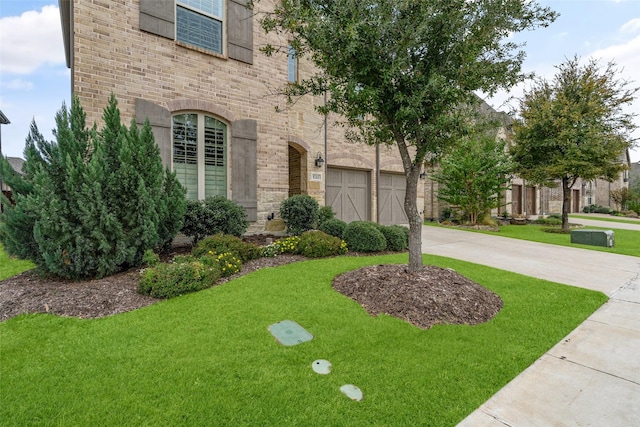 view of front of house featuring a garage and a front lawn