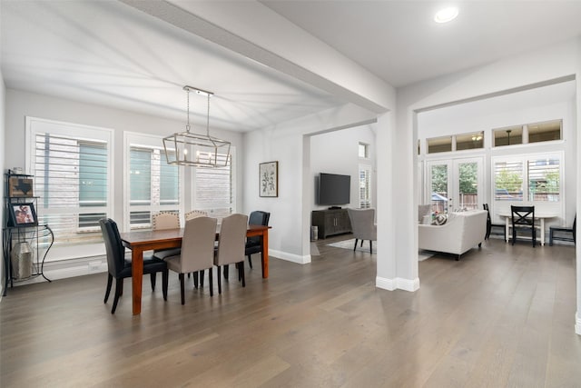 dining space with dark hardwood / wood-style floors and a notable chandelier