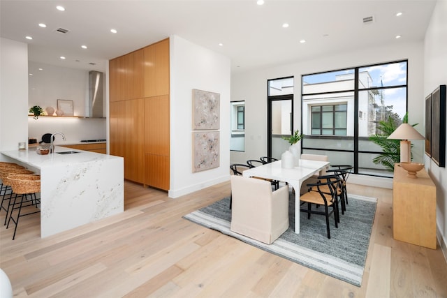 dining area with light wood finished floors, visible vents, and recessed lighting