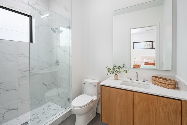 bathroom featuring toilet, vanity, and a marble finish shower