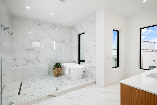 full bathroom with marble finish floor, a marble finish shower, recessed lighting, vanity, and a freestanding tub