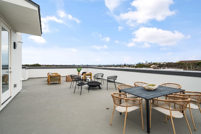 view of patio with a water view, a fire pit, and outdoor dining space