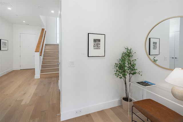 hallway with baseboards, stairway, light wood-type flooring, and recessed lighting