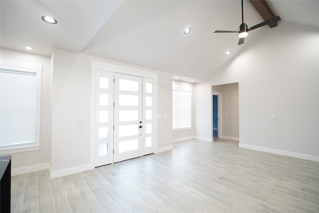 foyer entrance featuring beamed ceiling, ceiling fan, light wood-type flooring, and high vaulted ceiling