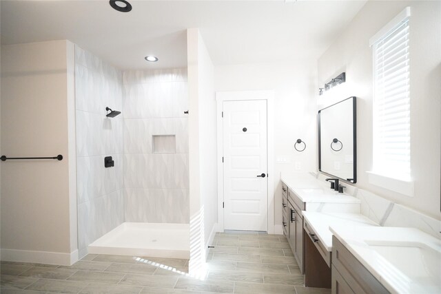 bathroom with a tile shower and vanity