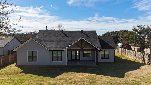 back of house with a lawn and a patio