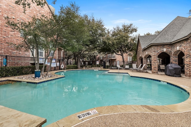 view of swimming pool with area for grilling and a patio area