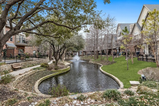 view of community with a water view and a lawn